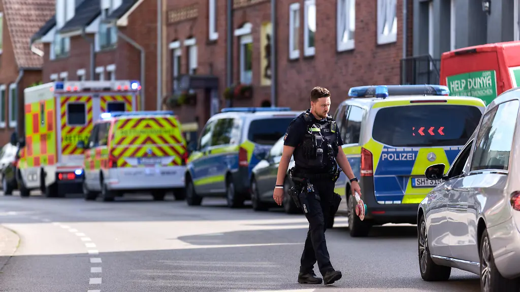 Ein-Polizist-ueberquert-eine-Strasse-am-Einsatzort-in-Richtung-Leichenwagen-Die-Polizei-hat-am-Vormittag-ein-totes-Kleinkind-gefunden-Mit-grosser-Wahrscheinlichkeit-handelt-es-sich-um-das-vermisste-Maedchen-wie-die-Polizei-mitteilte