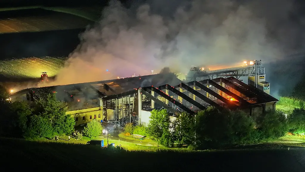 04-08-2026-Baden-Wuerttemberg-Ried-Die-Aufnahme-mit-einer-Drohne-zeigt-Feuerwehrleute-im-Einsatz-beim-Brand-eines-Schweinestalls-Im-Landkreis-Aichach-Friedberg-ist-ein-grosser-Schweinestall-komplett-abgebrannt-alle-1-600-Tiere-darin-starben-Das-sagte-ein-Polizeisprecher-am-spaeten-Abend