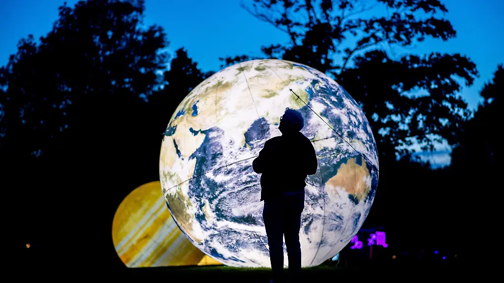 Auf-einer-Wiese-im-Park-sind-metergrosse-beleuchtete-Planeten-zu-sehen