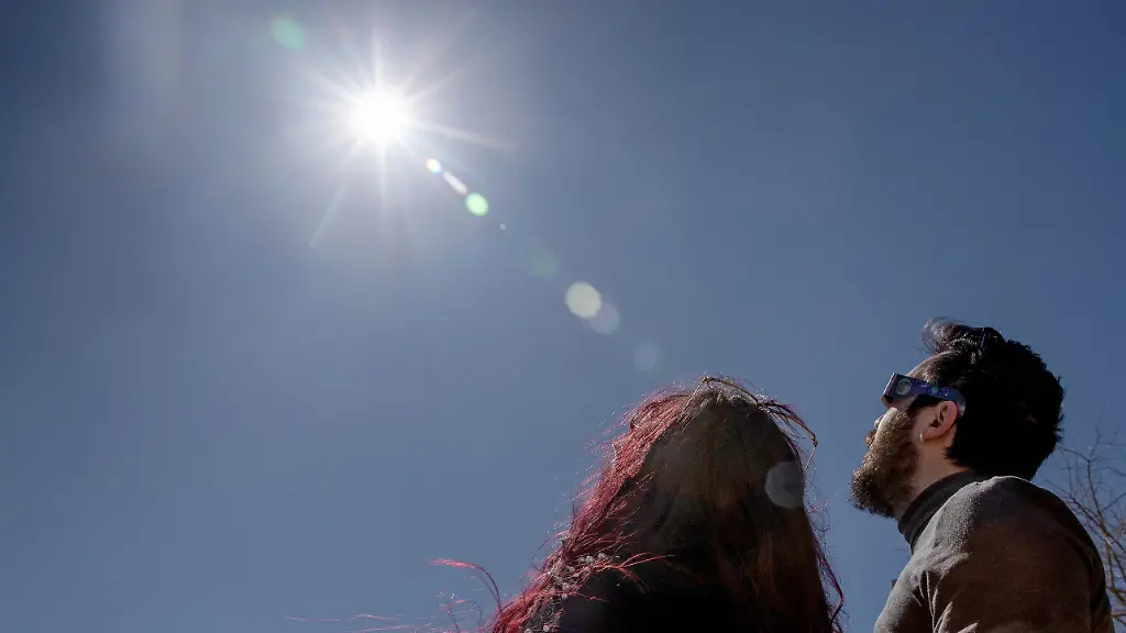 Maria-und-Adrian-beobachten-die-Sonne-waehrend-der-partiellen-Sonnenfinsternis-Das-Institut-fuer-Astronomie-und-Raumfahrt-von-Mallorca-hatte-zuvor-Brillen-verteilt-und-Teleskope-zur-Beobachtung-installiert