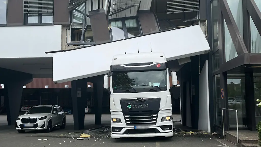 Ein-Lastwagen-steckt-unter-einer-Hausfassade-fest-Bei-der-Durchfahrt-ist-der-Lkw-in-Detmold-haengengeblieben