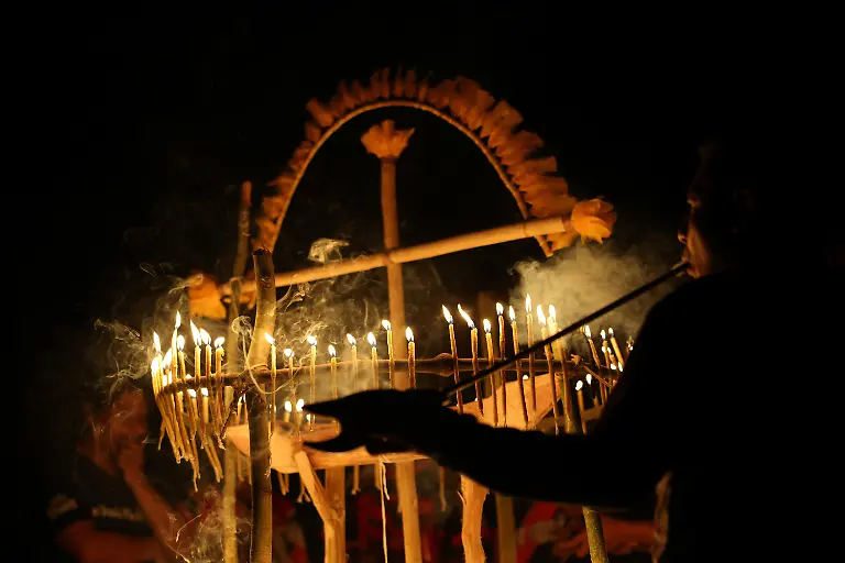 A-Guarani-Indigenous-man-smokes-a-petyngua-pipe-during-the-Nhemongarai-a-baptism-ritual-in-the-Opy-a-Guarani-prayer-house-at-Yvy-Pora-village-Jaragua-Indigenous-Territory-Sao-Paulo-Brazil-January-21-2026-Each-candle-represents-the-soul-of-the-person-who-places-it-on-the-altar-of-Nhanderu-the-Creator-God-When-this-candle-is-lit-the-sacred-flame-will-reveal-each-person-s-spiritual-strength-or-it-may-also-reveal-illnesses-that-the-person-needs-to-treat-with-the-shaman-REUTERS-Amanda-Perobelli-SEARCH-PEROBELLI-BRAZIL-BEES-FOR-THIS-STORY-SEARCH-WIDER-IMAGE-FOR-ALL-STORIES