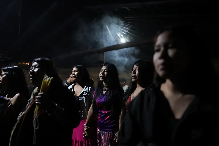 Guarani-Indigenous-women-sing-in-prayer-during-the-Nhemongarai-a-baptism-ritual-in-the-Opy-a-Guarani-prayer-house-in-Yvy-Pora-village-Jaragua-Indigenous-Territory-Sao-Paulo-Brazil-January-20-2026-It-s-through-song-that-the-voice-of-the-Guarani-people-reaches-our-god-Nhanderu-Candles-and-the-smoke-from-the-burning-wax-carry-that-song-up-to-Nhanderu-s-heaven-Marcio-Karai-said-REUTERS-Amanda-Perobelli-SEARCH-PEROBELLI-BRAZIL-BEES-FOR-THIS-STORY-SEARCH-WIDER-IMAGE-FOR-ALL-STORIES