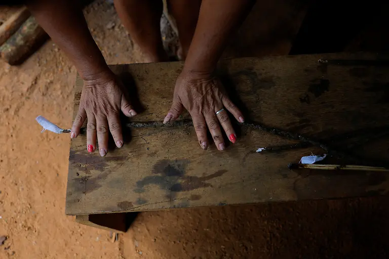 Irene-Mendonca-Marcio-Karai-s-mother-molds-a-handmade-candle-made-by-melting-native-beeswax-collected-locally-and-applying-it-to-pieces-of-fabric-a-tradition-passed-down-through-generations-as-they-prepare-for-the-Nhemongarai-a-baptism-ritual-in-the-Jaragua-Indigenous-Territory-in-Sao-Paulo-Brazil-January-13-2024-The-candles-are-made-by-Guarani-women-Karai-says-explaining-that-the-spiritual-world-is-strengthened-through-feminine-spirituality-REUTERS-Amanda-Perobelli-SEARCH-PEROBELLI-BRAZIL-BEES-FOR-THIS-STORY-SEARCH-WIDER-IMAGE-FOR-ALL-STORIES