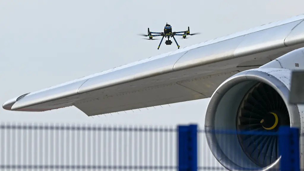 Eine-Drohne-der-Polizei-ist-ueber-einer-Flugzeugtragflaeche-zu-sehen-Nach-dem-naechtlichen-Drohnen-Vorfall-am-Flughafen-Leipzig-Halle-haben-Spezialisten-der-Bundespolizei-eine-Drohne-mit-einer-Sprengvorrichtung-entschaerft