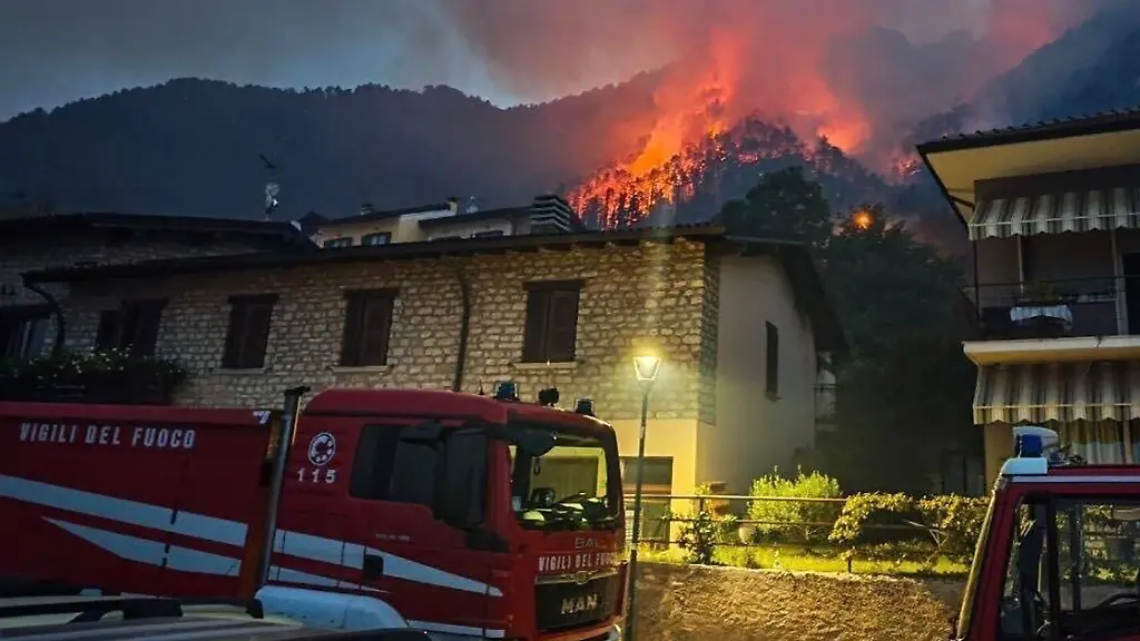 Die-Feuerwehr-loescht-Feuer-auf-dem-Gebiet-der-Gemeinde-am-Westufer-des-Gardasees-Wegen-des-Waldbrands-sind-mehr-als-200-Menschen-evakuiert-worden-darunter-auch-zahlreiche-Urlauber