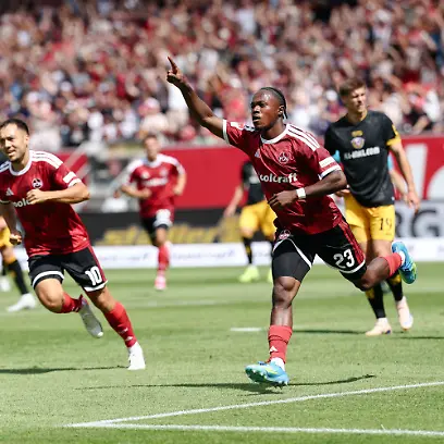 09-08-2026-Bayern-Nuernberg-Fussball-Maenner-2-Bundesliga-1-FC-Nuernberg-Dynamo-Dresden-1-Spieltag-Max-Morlock-Stadion-Mohamed-Ali-Zoma-1-FC-Nuernberg-M-jubelt-mit-Julian-Justvan-1-FC-Nuernberg-l-und-Piet-Scobel-1-FC-Nuernberg-nach-seinem-Tor-zum-1-0-Foto-Daniel-Loeb-dpa-WICHTIGER-HINWEIS-Gemaess-den-Vorgaben-der-Bundesliga-bzw-des-DFB-Deutscher-Fussball-Bund-ist-es-untersagt-in-dem-Stadion-und-oder-vom-Spiel-angefertigte-Fotoaufnahmen-in-Form-von-Sequenzbildern-und-oder-videoaehnlichen-Fotostrecken-zu-verwerten-bzw-verwerten-zu-lassen
