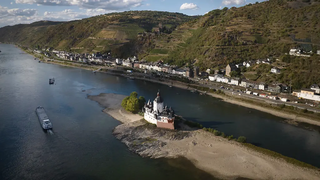 Ein-Schiff-faehrt-auf-dem-Rhein-bei-einem-niedrigen-Wasserstand-an-der-Burg-Pfalzgrafenstein-vorbei