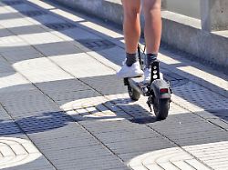 E Scooter Im Strassenverkehr Jugendliche Person Faehrt Mit Einem Elektroroller Modernes Fortbewegungsmittel In Der Stadt