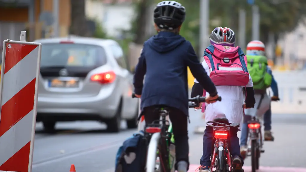 Kinder-fahren-mit-ihren-Raedern-waehrend-einer-Fahrraddemo-des-ADFC-Dresden-fuer-mehr-Sicherheit-auf-dem-Weg-zur-Schule-ueber-einen-symbolisch-ausgelegten-Fahrradweg-Beispielhaft-zeigt-der-Verband-an-dieser-Strasse-das-an-vielen-Stellen-der-Landeshauptstadt-die-Schulwegsicherheit-fuer-radfahrende-Schueler-weiterhin-sehr-eingeschraenkt-gewaehrleistet-ist