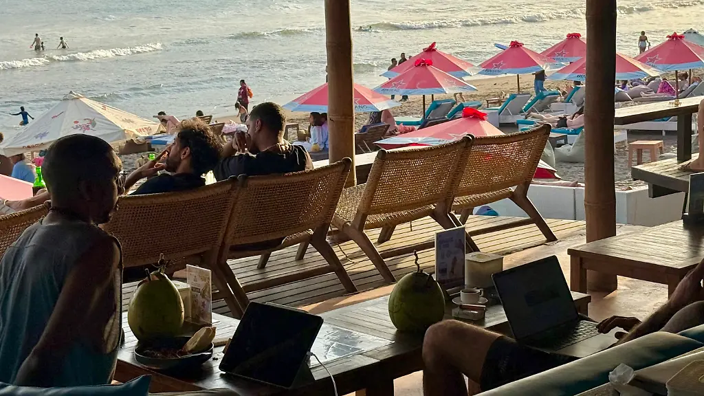 ARCHIV-22-06-2026-Indonesien-Canggu-Digitale-Nomaden-arbeiten-in-einem-Standcafe-in-Canggu-auf-Bali-In-dem-Kuestenort-leben-zahlreiche-digitale-Nomaden-die-morgens-surfen-und-dann-mobil-arbeiten