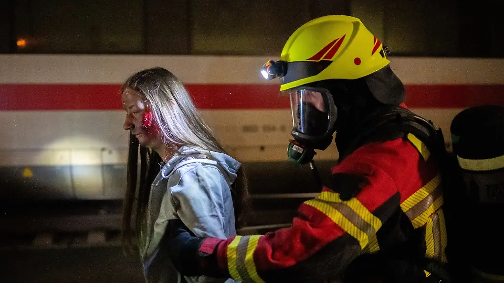 Ein-Erkundungstrupp-hat-einen-Menschen-gefunden-der-eine-verletzte-Person-darstellt-Feuerwehren-und-Rettungskraefte-aus-ganz-Thueringen-uebten-im-Eisenbahntunnel-Sandberg-im-Ilm-Kreis-den-Ernstfall-Rund-250-Einsatzkraefte-trainierten-bei-einer-Grossuebung-die-Rettung-von-Fahrgaesten-aus-einem-simulierten-Zugbrand-unterstuetzt-von-etwa-100-Komparsen-als-Zuginsassen-Die-Uebung-fand-im-Rahmen-einer-planmaessigen-Streckensperrung-auf-der-ICE-Strecke-Nuernberg-Erfurt-statt