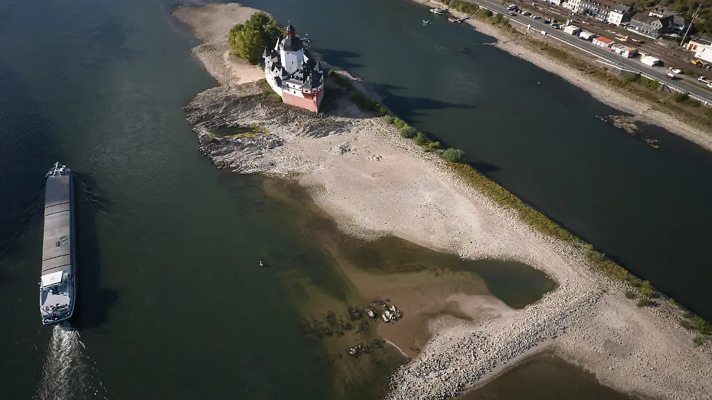 Ein-Schiff-faehrt-auf-dem-Rhein-bei-einem-niedrigen-Wasserstand-an-der-Burg-Pfalzgrafenstein-vorbei
