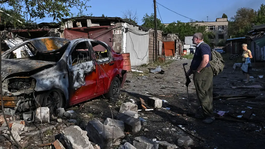 A-resident-looks-at-a-damaged-car-at-the-site-of-an-apartment-building-hit-by-a-Russian-air-strike-amid-Russia-s-attack-on-Ukraine-in-Zaporizhzhia-Ukraine-August-11-2026