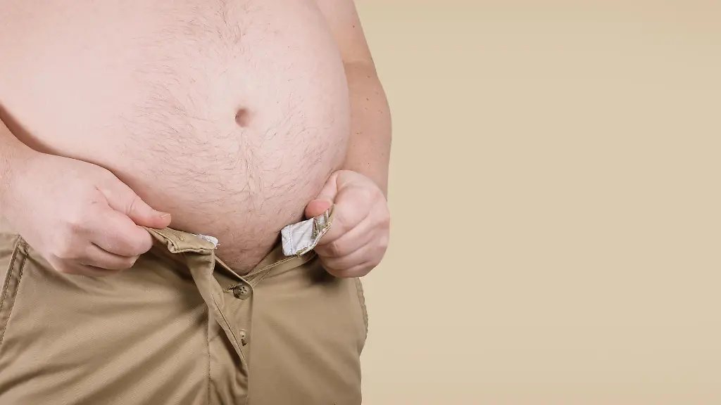 unrecognizable-overweight-corpulent-man-with-fat-belly-unable-to-fit-into-his-pants-obesity-and-adiposity-concept-in-wide-web-banner-format-with-copy-space-Modellfreigabe-vorhanden