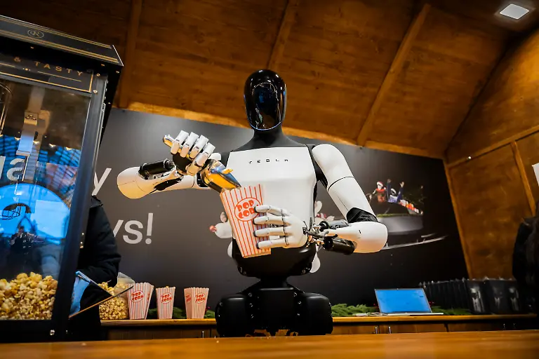 Der-humanoide-Roboter-Optimus-von-Tesla-verteilt-bei-seiner-Vorstellung-in-der-Mall-of-Berlin-Popcorn-an-einem-Weihnachtsmarktstand