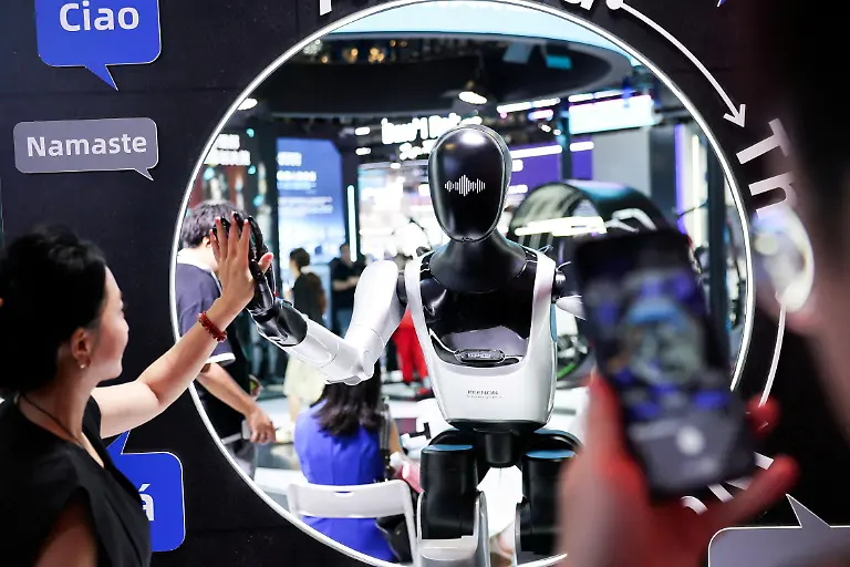 FILE-PHOTO-A-visitor-high-fives-a-humanoid-robot-at-the-Keenon-Robotics-booth-during-the-World-Artificial-Intelligence-Conference-WAIC-in-Shanghai-China-July-18-2026