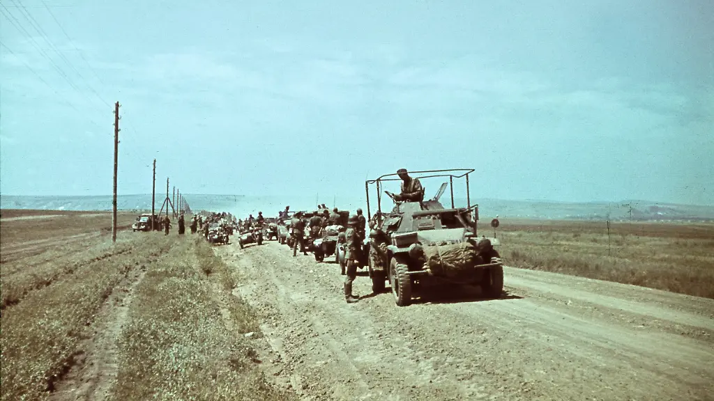 Geschichte-2-Weltkrieg-Ostfront-Schlacht-von-Kiew-Schliessung-des-Kessel-von-Kiew-durch-motorisierte-Einheiten-der-Wehrmacht-Hier-Spaehtrupp-der-3-Panzerdivision-weisses-G-auf-dem-rechten-Kotfluegel-und-Baerenwappen-auf-dem-linken-Kotfluegel-und-Maenner-der-16-Panzerdivision-Kraeder-mit-einem-grossen-weissen-K-auf-dem-Beiwagen-am-Morgen-nach-dem-Zusammentreffen-der-Spitzen-der-beiden-Divisionen-noerdlich-Lubny-In-der-Bildmitte-der-Filmberichterstatter-Hans-Bastanier-mit-dem-Akkukasten-fuer-die-Ariflex-Kamera-Lubny-Ukraine-15-09-1941