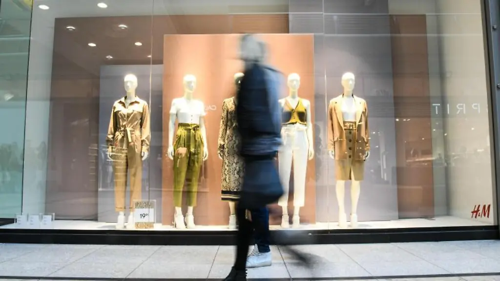 Eine-Frau-geht-vor-einem-Modegeschaeft-vorbei