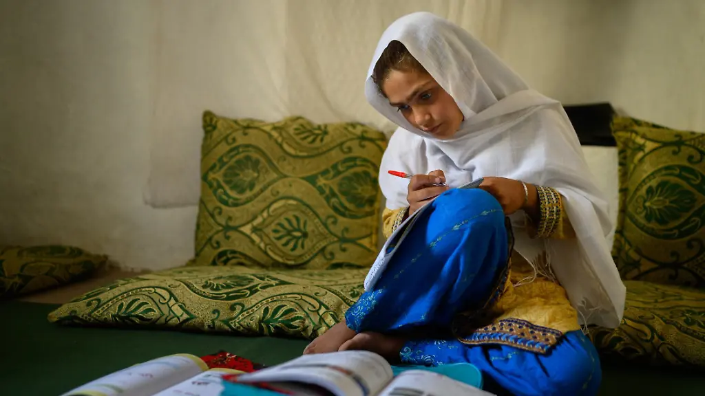 Die-zehnjaehrige-Hajira-aus-der-afghanischen-Provinz-Nangarhar-sitzt-in-einem-Haus-in-einem-abgelegenen-Dorf-oestlich-von-Kabul-ueber-Schulbuechern-und-lernt-undatierte-Aufnahme-Der-erste-Preis-des-Unicef-Foto-des-Jahres-2025-geht-an-Elise-Blanchard-Frankreich-fuer-ein-Bild-aus-ihrer-Reportage-Girlhood-in-Afghanistan-Seit-mehr-als-vier-Jahren-bleibt-Maedchen-in-Afghanistan-der-Zugang-zur-weiterfuehrenden-Schulbildung-verwehrt