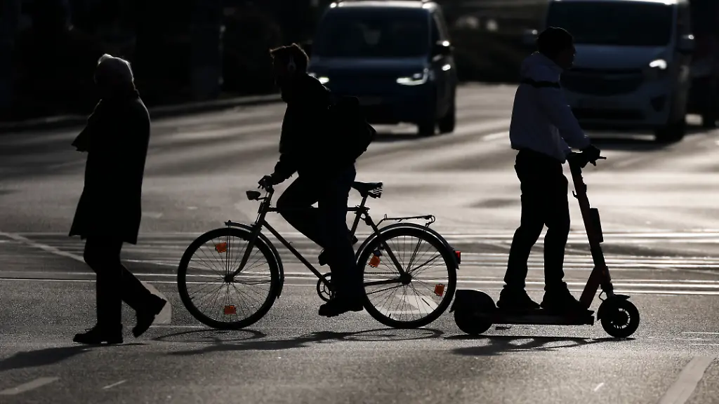 ARCHIV-18-12-2025-Sachsen-Leipzig-Ein-Fussgaenger-ein-Radfahrer-und-ein-Rollerfahrer-ueberqueren-den-Georgiring-am-Rande-der-Leipziger-Innenstadt-Sie-sind-im-Strassenverkehr-besonders-ungeschuetzt
