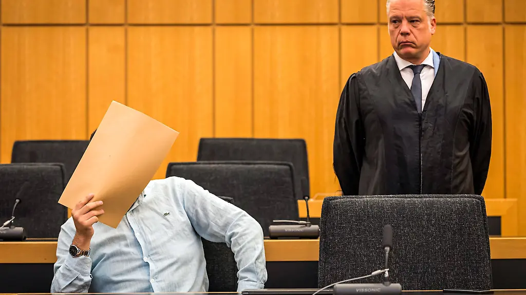 Der-Angeklagte-haelt-sich-vor-Beginn-des-Prozesses-im-Saal-des-Landgerichts-einen-Umschlag-vor-das-Gesicht