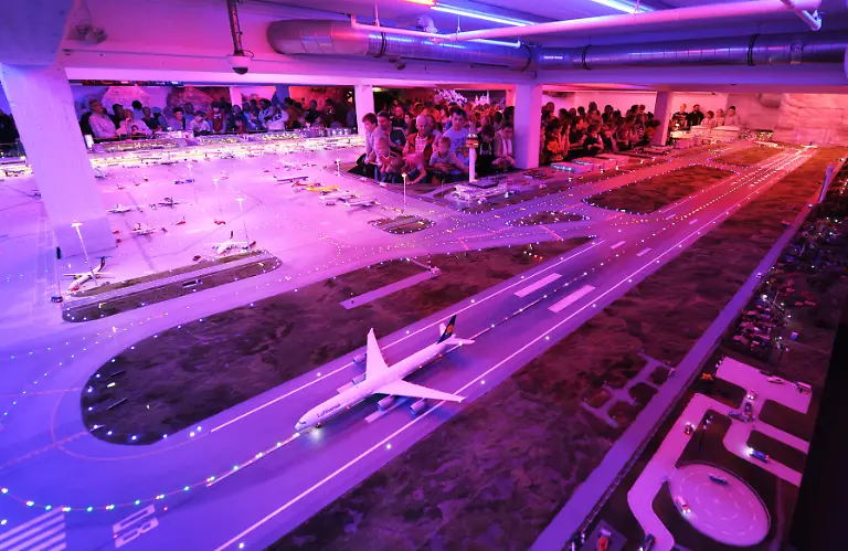 Besucher-betrachten-am-Freitag-12-08-2011-eine-Modell-Szenerie-des-Flughafen-Knuffingen-in-der-Miniatur-Wunderland-Modelleisenbahn-in-Hamburg-Am-Dienstag-feiert-das-Miniatur-Wunderland-sein-10-jaehriges-Jubilaeum-Seit-der-Eroeffnung-am-16-August-2001-haben-rund-8-3-Millionen-Besucher-die-groesste-Modelleisenban-der-Welt-in-der-Hamburger-Speicherstadt-gesehen
