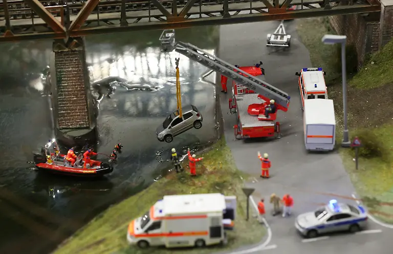 Eine-Miniatur-Szene-zeigt-die-Bergung-eines-Autos-aus-einem-Gewaesser-durch-Helfer-von-DLRG-und-Feuerwehr-am-14-02-2013-im-Miniatur-Wunderland-in-Hamburg-Zum-100-Geburtstag-der-Rettungsorganisation-eroeffnete-die-Modelleisenbahn-Miniatur-Wunderland-am-Donnerstag-eine-DLRG-Wachstation-in-Knuffingen