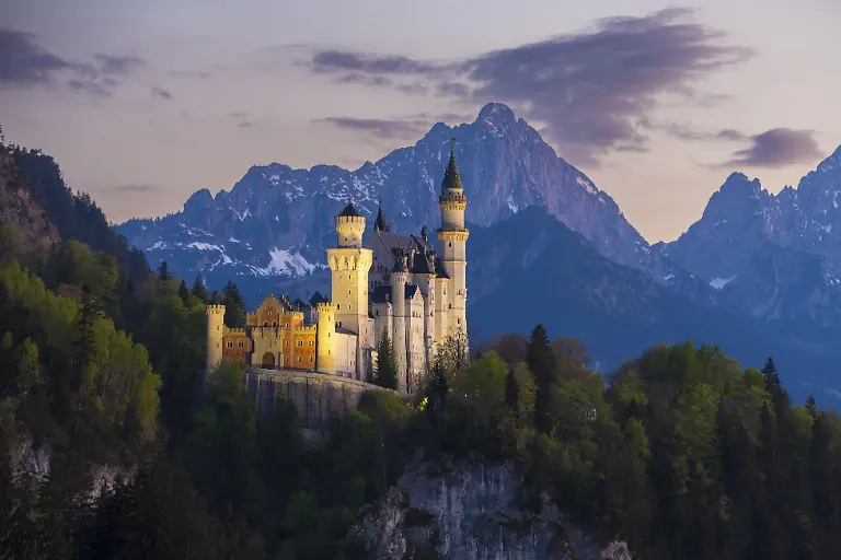 Maerchenschloss-vor-Bergkulisse-im-sanften-Abendlicht-Neuschwanstein-Schwangau-bei-Fuessen-Landkreis-Ostallgaeu-Schwaben-Bayern-Deutschland-Europa