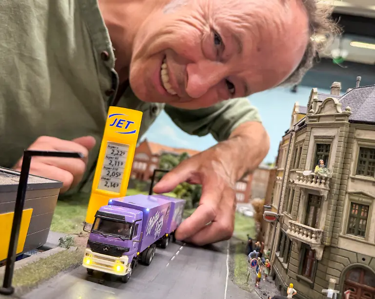 Gerrit-Braun-einer-der-Gruender-und-Geschaeftsfuehrer-des-Miniatur-Wunderland-beugt-sich-ueber-das-erste-Auto-ein-LKW-mit-Anhaenger-das-auf-den-Strassen-des-Miniatur-Wunderlands-fuhr-Die-Brueder-Gerrit-und-Frederik-Braun-haben-2001-die-mittlerweile-groesste-Modelleisenbahnanlage-der-Welt-in-der-Speicherstadt-eroeffnet-und-damit-eine-Rekord-Touristen-Attraktion