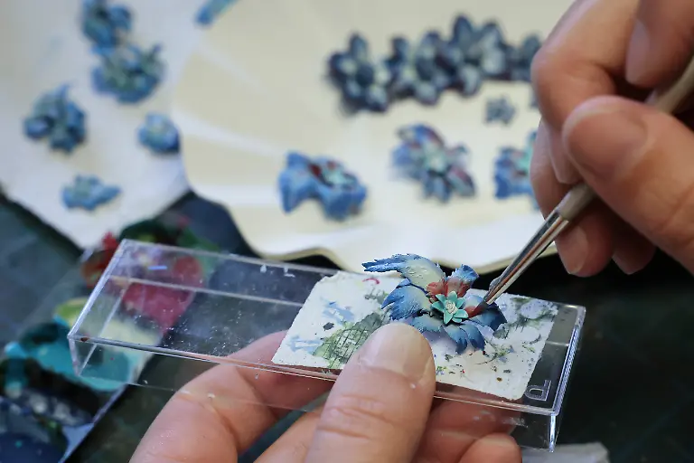 Leonie-Vogt-Modellbauerin-im-Bereich-Gestaltung-bemalt-Blumen-und-Pflanzen-fuer-eine-neue-Themenlandschaft-in-einer-Werkstatt-im-Miniatur-Wunderland-zu-sehen-Die-Brueder-Gerrit-und-Frederik-Braun-haben-2001-die-mittlerweile-groesste-Modelleisenbahnanlage-der-Welt-in-der-Speicherstadt-eroeffnet-und-damit-eine-Rekord-Touristen-Attraktion