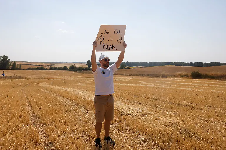 Cristian-Casorran-42-poses-wearing-a-foil-hat-and-holding-a-sign-ahead-of-a-solar-eclipse-in-Villalibado-Spain-August-12-2026