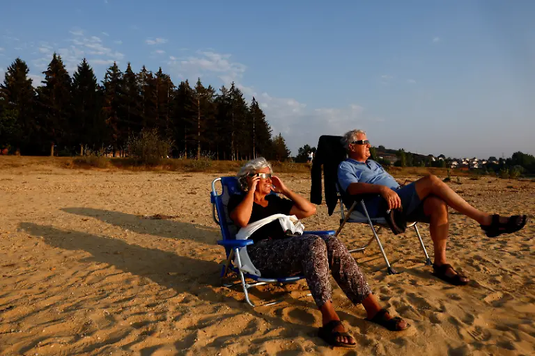Patricia-Molera-and-Enrique-Sotomayor-test-their-eclipse-glasses-during-sunset-at-Arija-beach-Spain-August-11-2026