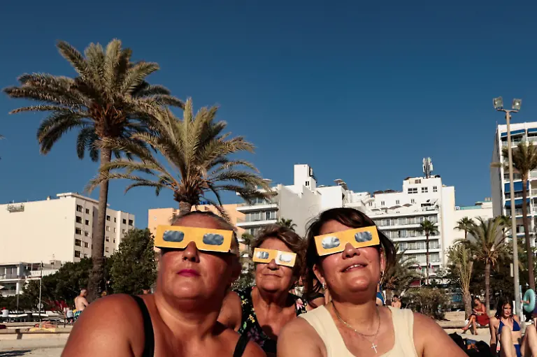 People-from-Cologne-Germany-test-their-protective-glasses-ahead-of-a-solar-eclipse-at-El-Arenal-beach-in-Mallorca-Spain-August-12-2026