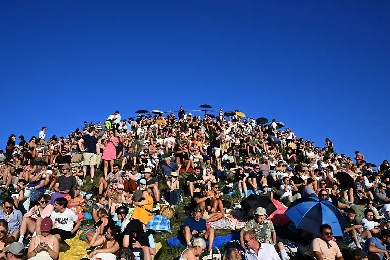 Menschen-betrachten-eine-partielle-Sonnenfinsternis-am-Olympiaberg-im-Muenchner-Olympiapark-Wenn-am-Abend-die-partielle-Sonnenfinsternis-ueber-Deutschland-zu-sehen-ist-herrschen-zu-dieser-Zeit-fast-ueberall-auch-optimale-Wetterbedingungen-um-sie-zu-beobachten-hiess-es-vom-Deutschen-Wetterdienst