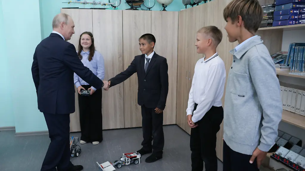 Russian-President-Vladimir-Putin-left-interacts-with-schoolchildren-as-he-visits-a-secondary-school-named-after-Eduard-Norpolov-in-Kurilsk-on-the-Iturup-Island-the-largest-of-the-Kuril-Islands-of-Russia-s-far-east-on-Thursday-Aug-13-2026