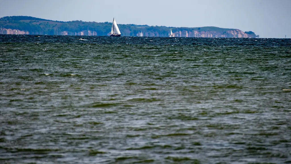 Ein-Segelschiff-faehrt-auf-dem-Greifswalder-Bodden-vor-der-Insel-Ruegen