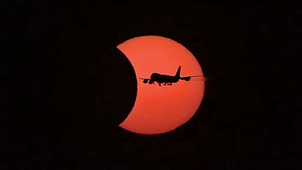 Ein-Flugzeug-vom-Typ-Boeing-747-fliegt-waehrend-der-partiellen-Sonnenfinsternis-vor-der-teilweise-vom-Mond-verdeckten-Sonne