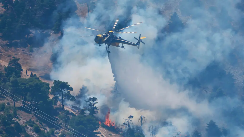 Ein-Loeschhubschrauber-wirft-Wasser-ueber-einen-Waldbrand-auf-dem-Berg-Kithairon-in-der-Naehe-von-Porto-Germeno-nordwestlich-von-Athen-ab-Die-Wald-und-Buschbraende-westlich-der-griechischen-Hauptstadt-sind-noch-nicht-unter-Kontrolle