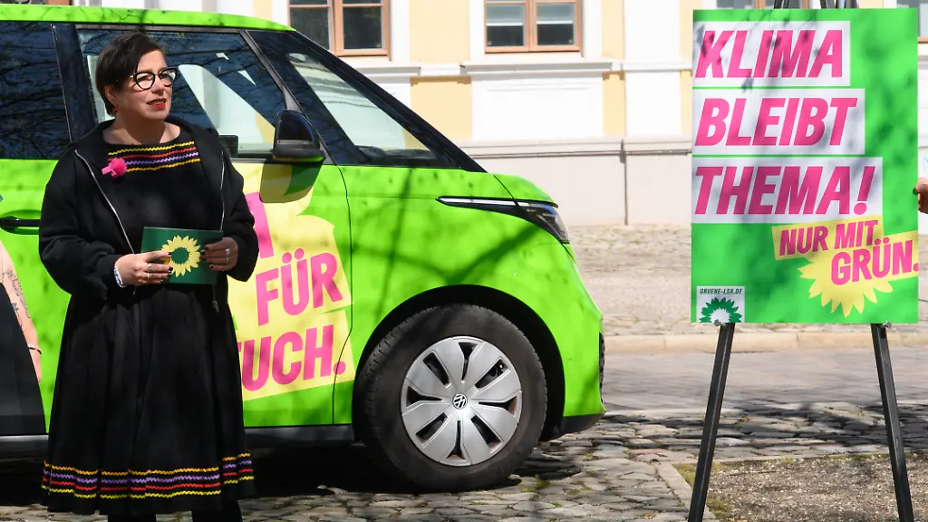 Susan-Sziborra-Seidlitz-Spitzenkandidatin-von-Buendnis-90-Die-Gruenen-bei-der-Landtagswahl-2026-in-Sachsen-Anhalt-steht-vor-ihrem-Wahlkampfbus-und-stellt-die-Kampagne-der-Landtagsfraktion-der-Gruenen-vor-Auf-einem-Plakat-ist-Klima-bleibt-Thema-zu-lesen