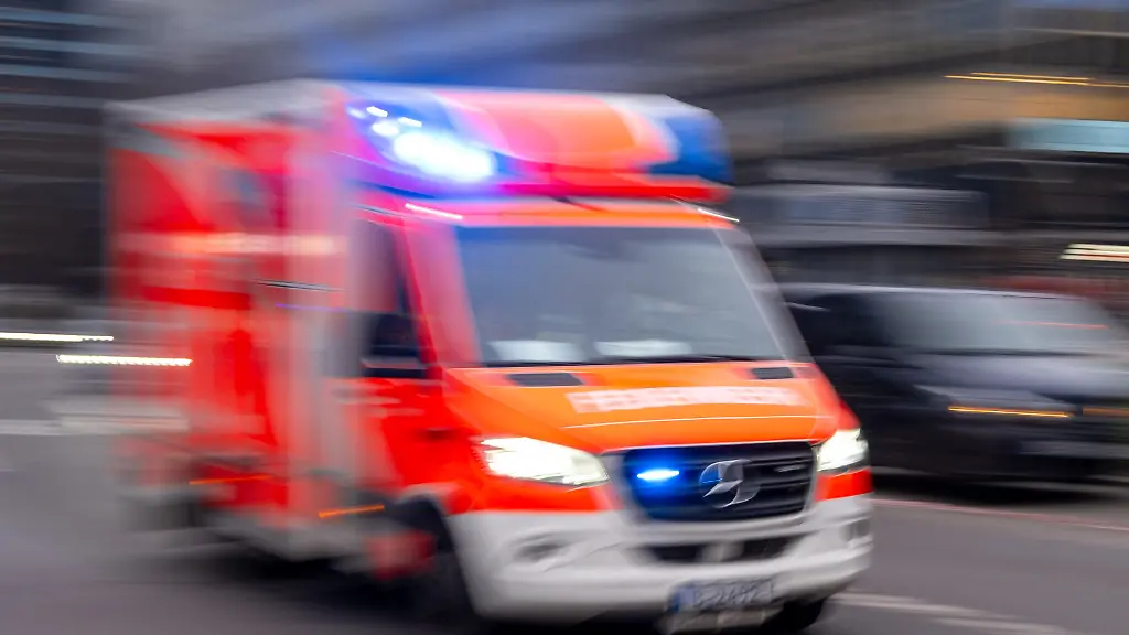 Ein-Rettungswagen-der-Feuerwehr-faehrt-mit-Blaulicht-zum-Einsatz-Aufnahme-mit-Langzeitbelichtung