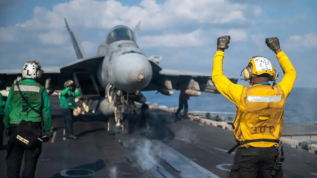 Ein-Soldat-der-US-Marine-gibt-einer-F-A-18E-Super-Hornet-das-Signal-zum-Start-vom-Flugdeck-des-Flugzeugtraegers-USS-Abraham-Lincoln-der-Nimitz-Klasse-waehrend-der-Operation-Epic-Fury-Die-Vereinigten-Staaten-und-Israel-fuehrten-gemeinsame-Angriffe-auf-den-Iran-durch