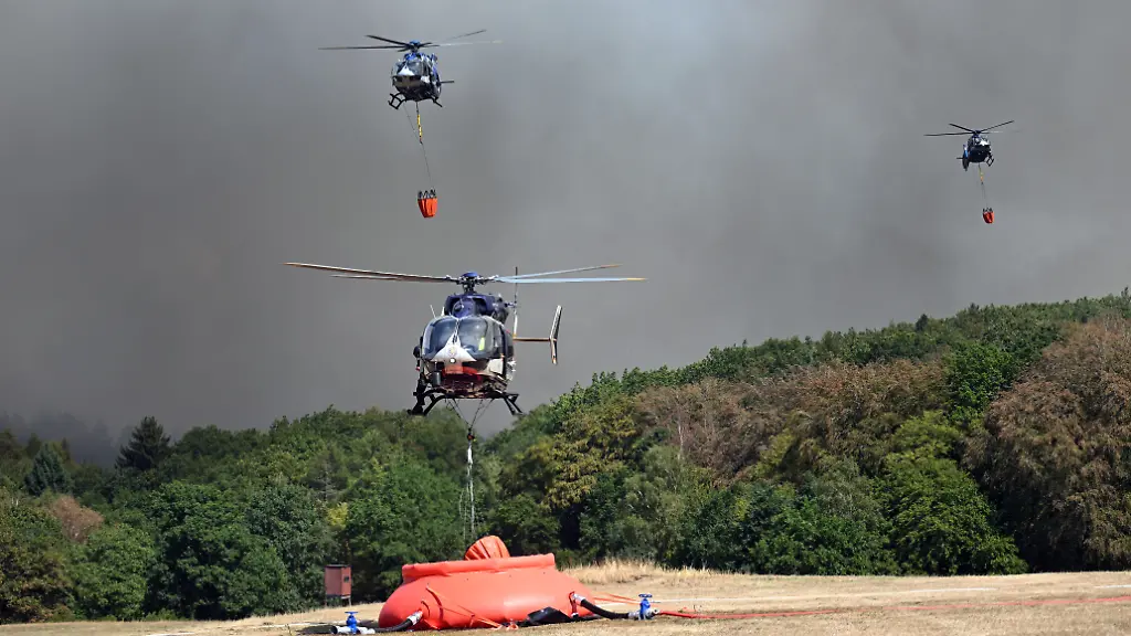 Helikopter-fliegen-an-um-Wasser-in-Loeschwasser-Aussenlastbehaeltern-zum-Einsatz-beim-Waldbrand-im-Huertgenwald-aufzunehmen-Mehrere-Hundert-Hektar-Waldflaeche-stehen-in-Flammen
