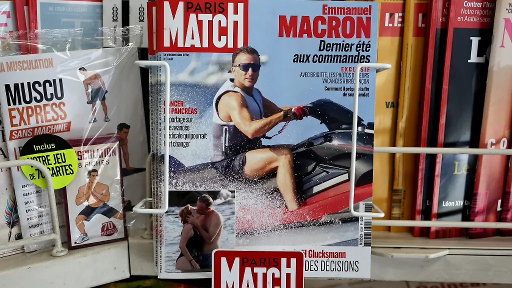 This-photograph-taken-in-Paris-on-August-14-2026-shows-the-cover-of-French-magazine-Paris-Match-depicting-France-s-President-Emmanuel-Macron-on-a-jet-ski-during-his-holiday-near-the-Presidential-residence-in-Bregancon-south-eastern-France-Emmanuel-Macron-is-facing-a-new-trial-for-being-out-of-touch-criticised-over-a-Paris-Match-feature-in-which-he-is-photographed-enjoying-various-water-activities-including-jet-skiing-in-the-middle-of-a-summer-marked-for-the-French-by-successive-heatwaves-and-wildfires