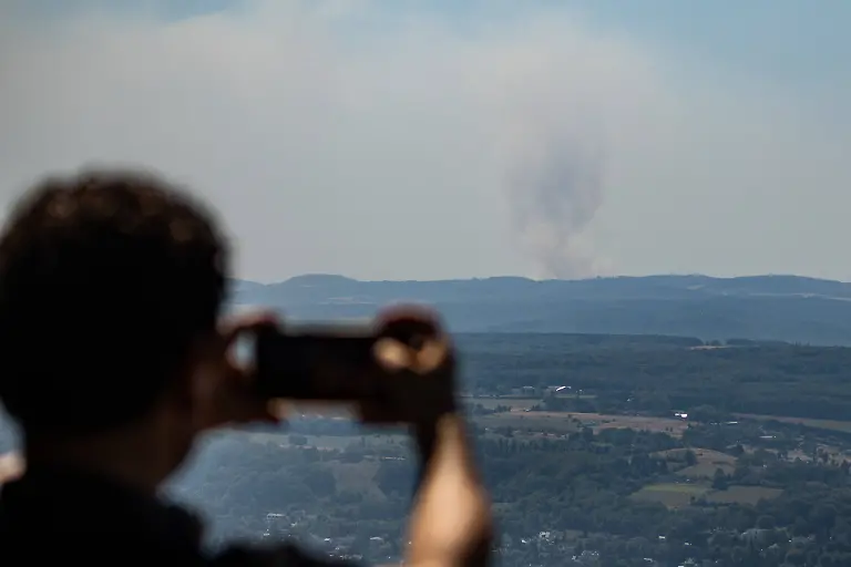 Blick-vom-Petersberg-auf-die-Rauchwolken-zweier-Waldbraende-Vom-Petersberg-in-Koenigswinter-bei-Bonn-aus-zieht-sich-der-Brandrauch-des-rund-63-Kilometer-entfernten-Waldbrands-im-Huertgenwald-Kreis-Dueren-NRW-wie-eine-Nebelwolke-ueber-die-Bonner-Region-Vom-rund-34-Kilometer-entfernten-Waldbrand-bei-Langscheid-in-der-Vordereifel-Kreis-Mayen-Koblenz-Rheinland-Pfalz-ist-dagegen-nur-die-Rauchsaeule-zu-erkennen-der-dortige-Brandrauch-erreicht-die-Bonner-Region-nicht-Fuer-Bonn-und-den-Rhein-Sieg-Kreis-gilt-dennoch-eine-NINA-Gefahreninformation-zu-Brandrauch-und-Geruchsbelaestigung-Koenigswinter-Petersberg-Nordrhein-Westfalen-Deutschland-View-from-Petersberg-of-the-smoke-plumes-from-two-wildfires