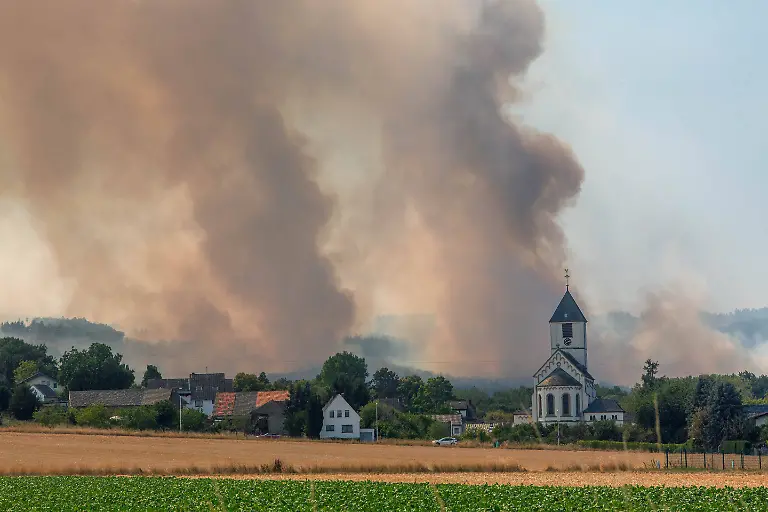 Der-Brand-im-Huertgenwald-Kreis-Dueren-NRW-breitet-sich-hinter-der-Ortschaft-Birgel-mit-der-Pfarrkirche-Sankt-Martinus-aus-Brand-im-Huertgenwald-The-fire-in-the-Huertgenwald-Dueren-County-North-Rhine-Westphalia-is-spreading-behind-the-village-of-Birgel-where-the-St-Martinus-parish-church-is-located