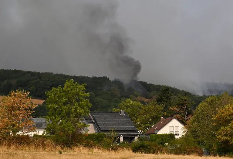 Smoke-rises-from-a-forest-fire-in-Huertgenwald-western-Germany-on-August-14-2026-Around-1-800-people-had-to-leave-their-homes-in-western-Germany-overnight-as-a-wildfire-spread-nearby-officials-said-with-helicopters-and-army-equipment-deployed-to-help-battle-the-flames-A-district-of-the-town-of-Huertgenwald-near-the-Belgian-and-Dutch-borders-was-evacuated-after-the-fire-expanded-from-25-hectares-around-60-acres-to-300-hectares-by-Friday-morning