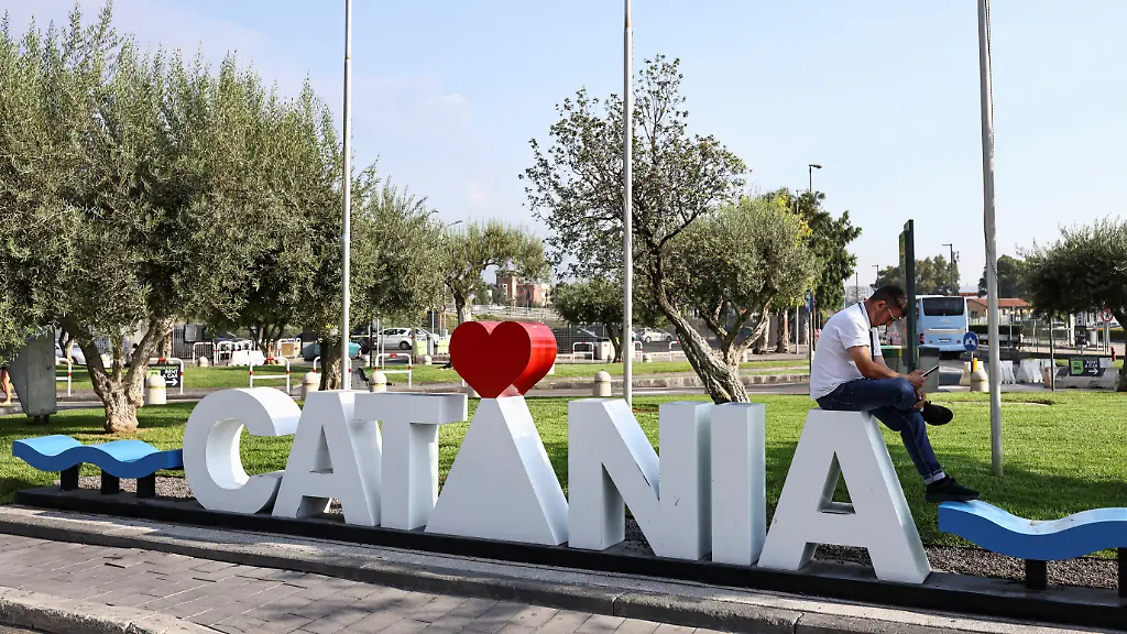 A-man-sits-outside-the-Vincenzo-Bellini-Catania-Airport-following-the-closure-of-the-airport-due-to-an-ash-cloud-from-Sicily-s-Mount-Etna-eruption-in-Catania-Italy-August-14-2026