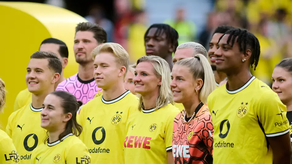 15-08-2026-Nordrhein-Westfalen-Dortmund-Fussball-Testspiele-Borussia-Dortmund-AS-Rom-Saisoneroeffnung-Borussia-Dortmund-Alexandra-Popp-steht-bei-der-Teampraesentation-zwischen-Spielern-und-Spielerinnen-der-Damen-und-Herrenmannschaft-von-Borussia-Dortmund-Foto-Bernd-Thissen-dpa-WICHTIGER-HINWEIS-Gemaess-den-Vorgaben-der-Bundesliga-bzw-des-DFB-Deutscher-Fussball-Bund-ist-es-untersagt-in-dem-Stadion-und-oder-vom-Spiel-angefertigte-Fotoaufnahmen-in-Form-von-Sequenzbildern-und-oder-videoaehnlichen-Fotostrecken-zu-verwerten-bzw-verwerten-zu-lassen