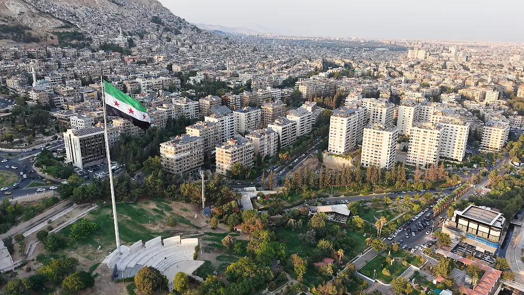 A-drone-view-shows-Umayyad-Square-in-Damascus-Syria-on-August-14-2026-with-a-large-Syrian-flag-flying-over-the-plaza-and-surrounding-city-landscape